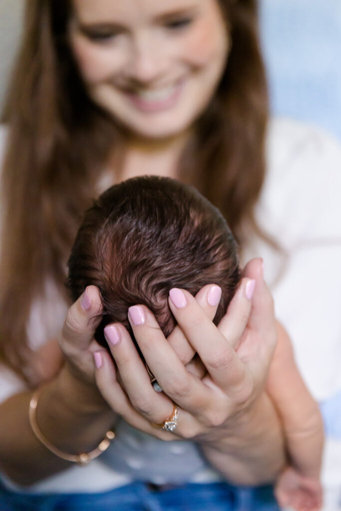 Close up image of Mama holding her baby and smiling down at him at his newborn lifestyle session