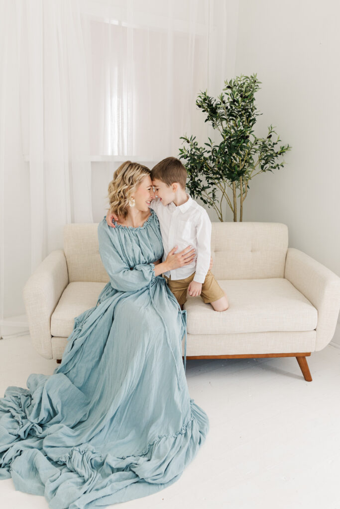 Boy and mom sit nose to nose on couch at Flowery Branch studio